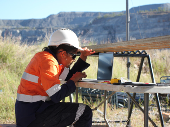 Female engineer looking at a laptop in the field