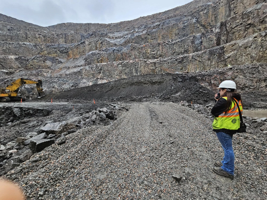 Female engineer talking on a walkie talkie inside a mining pit